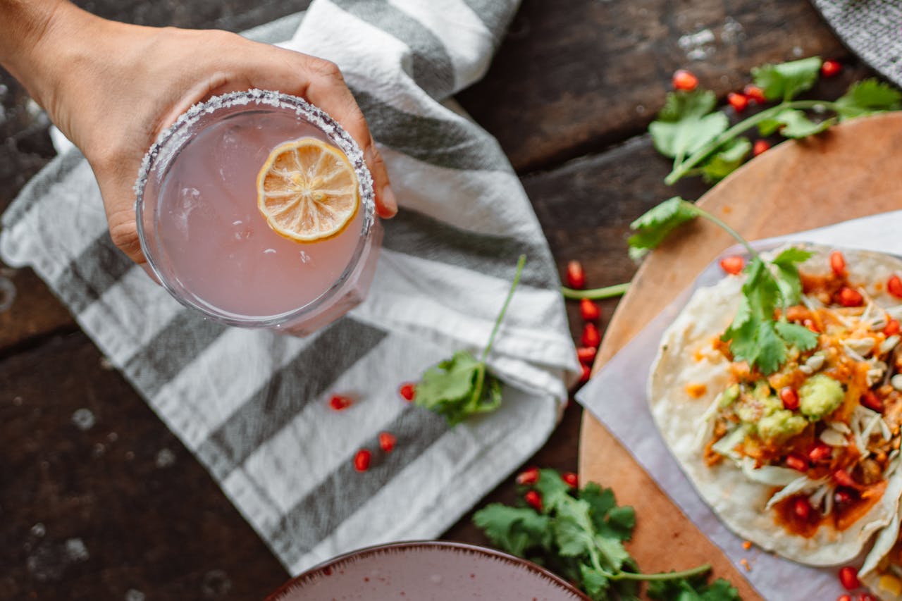 The Art of Drawing Readers In: Your attractive post title goes here A refreshing pink cocktail with a salted rim alongside a vibrant taco topped with fresh ingredients.